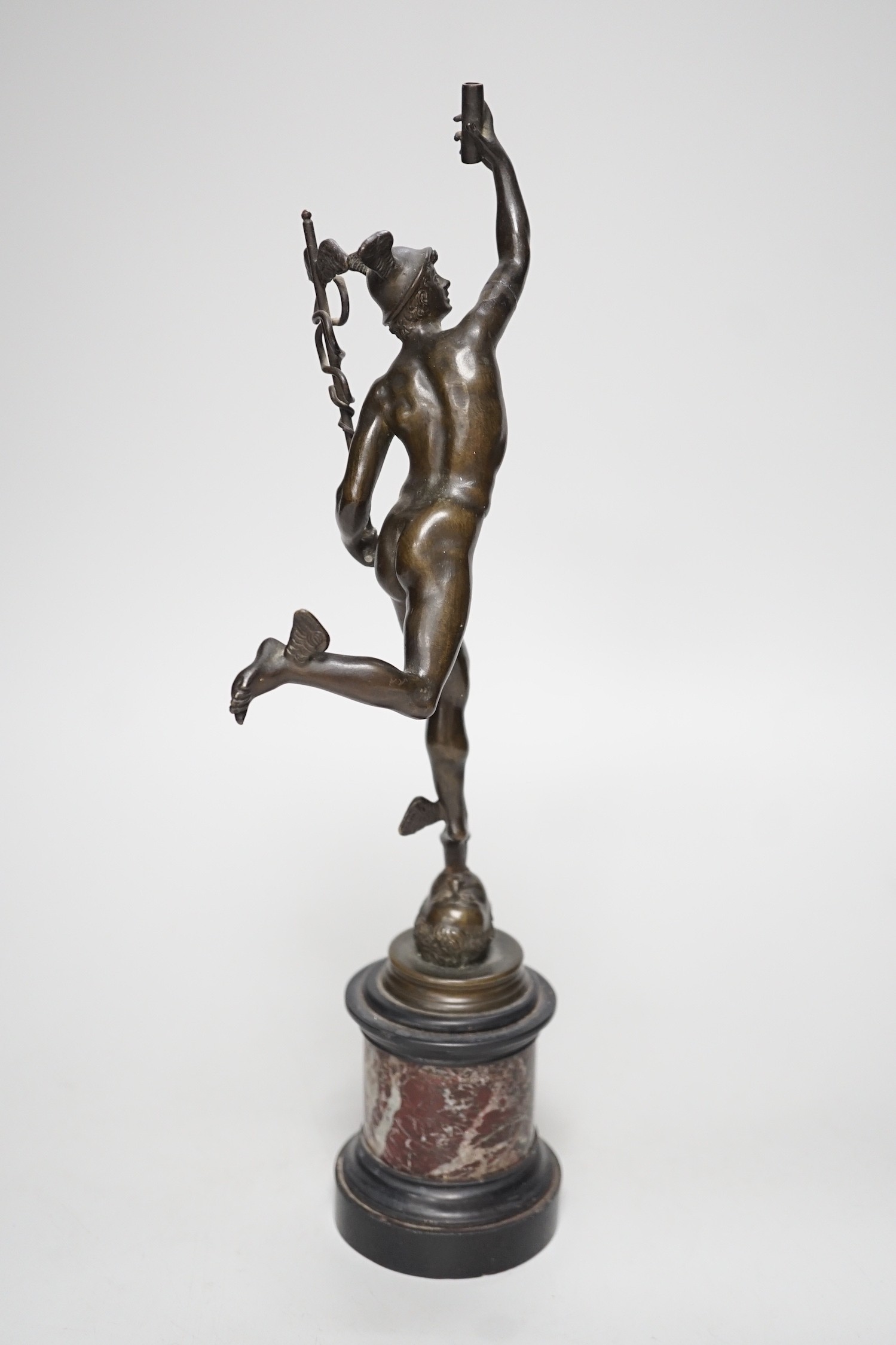 A bronze figure of Mercury on a graduated marble plinth. 33cm tall
